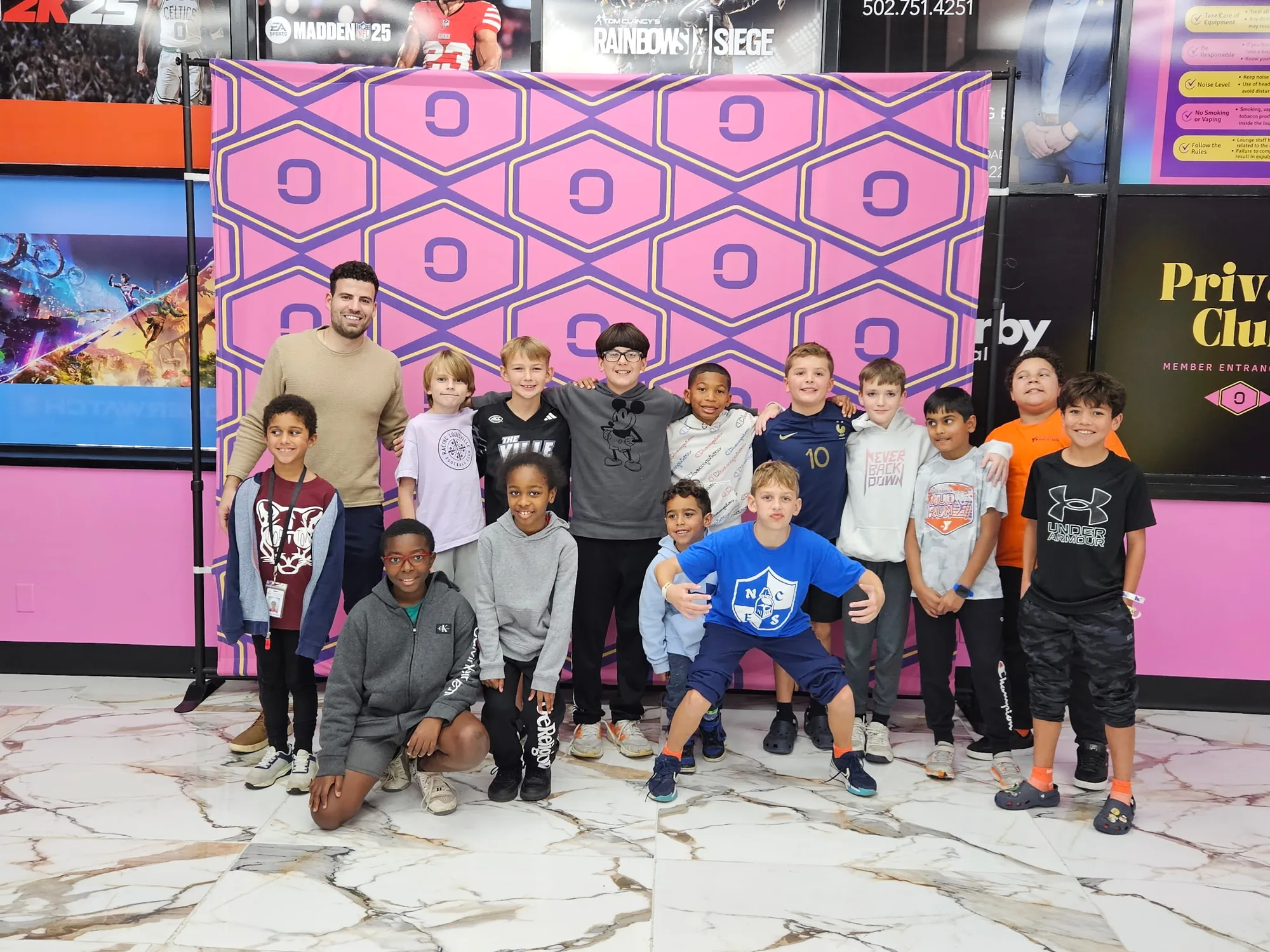 Party group photo in front of the Olympus hex wall