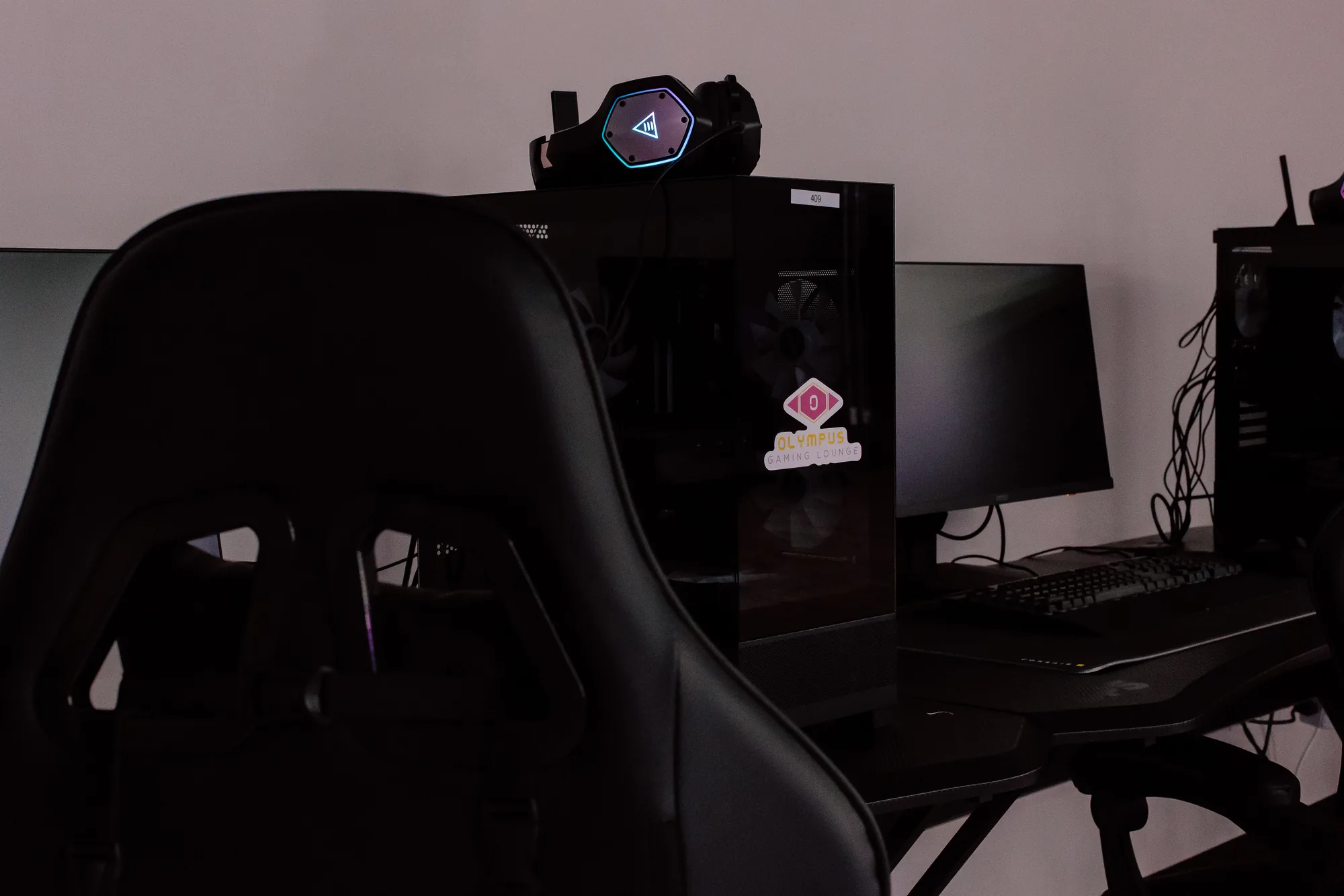 Row of gaming PCs with Olympus branded headsets